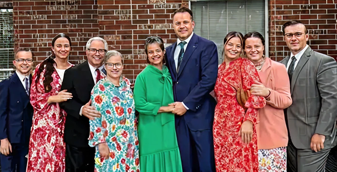 Group of people smiling in formal attire.